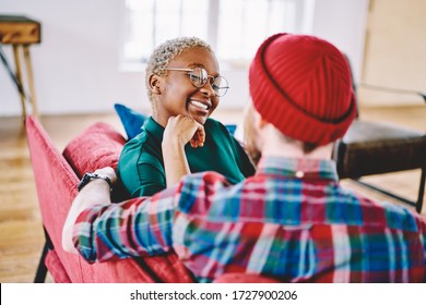 Diverse Male And Female Hipsters Having Positive Conversation Enjoying Together Resting During Weekend At Home Interior, Cheerful Couple In Love Talking About Multiracial Relationships At Apartment