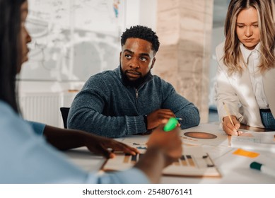 Diverse marketing team collaborating on data analysis, reviewing charts and graphs during a productive office meeting - Powered by Shutterstock