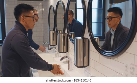 Diverse Men Washing Hands In Washroom Sink Of Business Center Or Restaurant