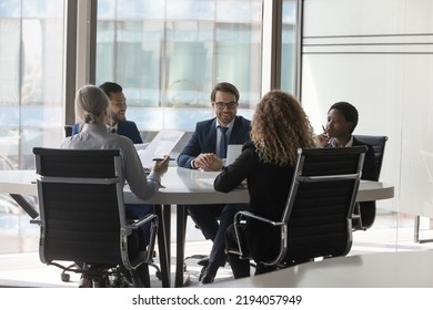 Diverse millennial business group brainstorming, at conference table. Startup leaders, project investors meeting, analyzing marketing reports, negotiating on investment, deal