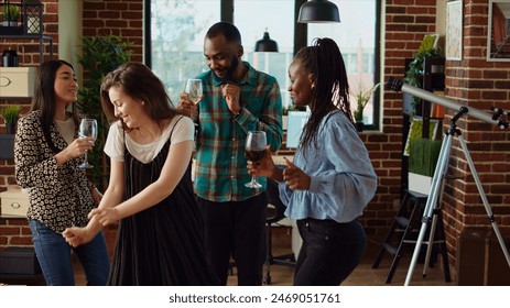 Diverse mix of guests at home party sharing laughter and dance moves in living room, dolly in shot. Friends dancing on disco beats during weekend hangout, shaking their shoulders - Powered by Shutterstock