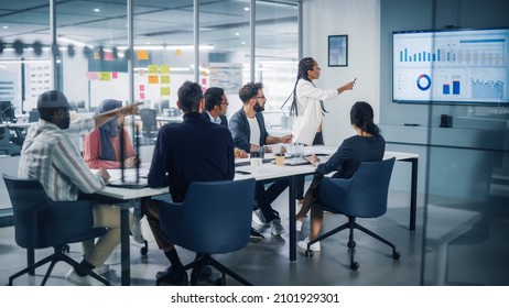 Diverse Modern Office: Black Businesswoman Leads Business Meeting With Managers, Talks, Uses Presentation TV With Statistics, Graphs, Big Data. Digital Entrepreneurs Work On ECommerce Project