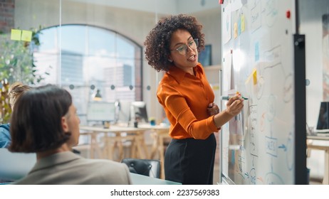 Diverse Modern Office: Black Businesswoman Leads Business Meeting with Managers, Talks, Explains Statistics, Uses a Whiteboard with Graphs, Big Data. Digital Entrepreneurs Work on eCommerce Project - Shutterstock ID 2237569383