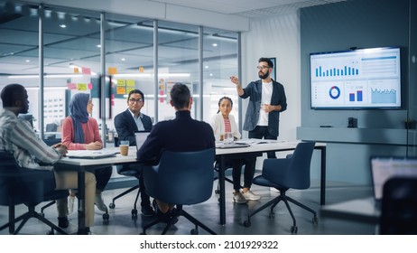 Diverse Modern Office: Businessman Leads Business Meeting with Managers, Talks, uses Presentation TV with Statistics, Infographics. Digital Entrepreneurs Work on e-Commerce Project. - Powered by Shutterstock