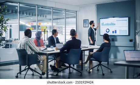Diverse Modern Office: Motivated Latin Businessman Leads Business Meeting With Managers, Talks About Company Growth, Uses TV For Presentation. Creative Digital Entrepreneurs Work On E-Commerce Project