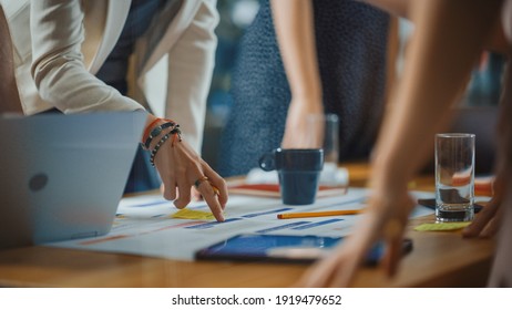 Diverse Multi Ethnic Team of Professional Businesspeople Meeting in the Modern Office Conference Room. Creative Team Gathers Around Table to Discuss App Design, Analyze Data. Focus on Desk and Hands - Shutterstock ID 1919479652