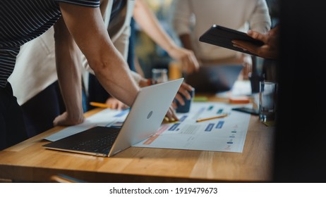 Diverse Multi Ethnic Team of Professional Businesspeople Meeting in the Modern Office Conference Room. Creative Team Gathers Around Table to Discuss App Design, Use Laptop. Focus on Desk and Hands - Shutterstock ID 1919479673