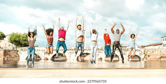 Diverse multi racial friends jumping at Rimini city - Happy urban  guys and girls having fun around old town location - University students on travel life style vacation concept - Bright warm filter - Shutterstock ID 2279565735