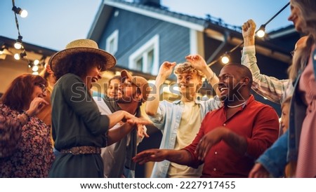 Diverse Multicultural Friends and Family Dancing Together at an Outdoors Garden Party Celebration. Young and Senior People Having Fun on a Perfect Summer Afternoon.