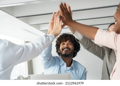 Diverse Multi-ethnic Business Team Bonding And Success, Teamwork And Unity. Happy People Excited Creative Group Raising Hands Up Giving High Five Together Celebrating Winning And Triumph