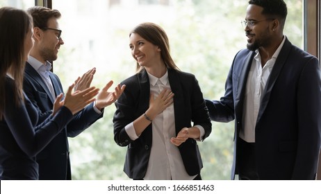 Diverse multiethnic businesspeople applaud greeting with promotion young female colleague at meeting, multiracial coworkers clap hands thanking for presentation or business success to woman employee - Shutterstock ID 1666851463