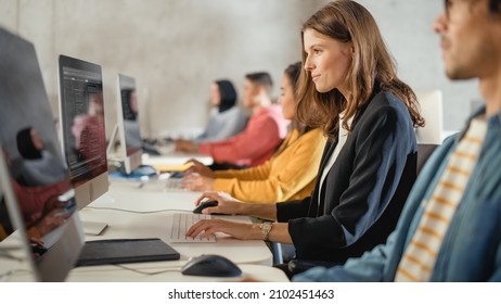 Diverse Multiethnic Group of Female and Male Students Sitting in College Room, Learning Computer Science. Young Scholars Study Information Technology on Computers in University, Writing Code in Class.