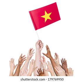 Diverse Multiethnic Hands Holding And Reaching For The Flag Of Vietnam