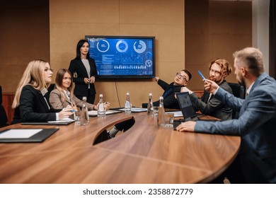 A diverse multinational team of professional business people meet in the conference room of a modern office. Creative team at the table discussing data analysis and planning a marketing campaign - Powered by Shutterstock