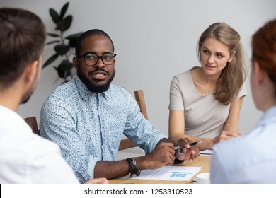 Diverse multinational young professional millennial company members gathered together in office boardroom listening with distrust black african speaker presenting sharing new creative ideas and plans