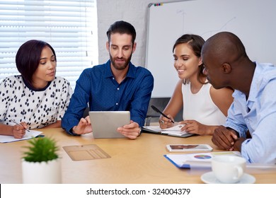 Diverse Multiracial Colleagues Discussing Tech Startup Business Ideas On Tablet Computer Device