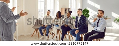 Diverse, multiracial, multiethnic audience sitting on chairs at business training workshop lesson, listening to professional team coach speaker, and learning about new sales techniques and lifehacks