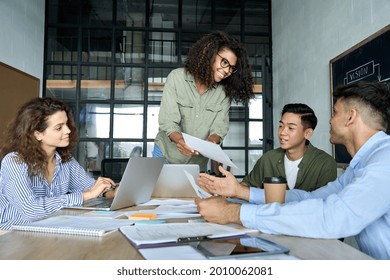 Diverse multiracial young happy cheerful coworkers business startup creative team people students discussing project results with African american mentor leader in contemporary office using laptops. - Powered by Shutterstock