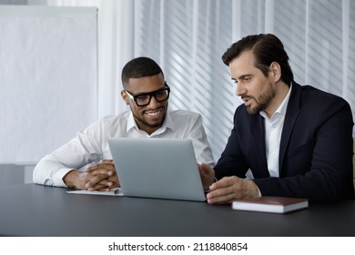 Diverse Office Employees In Formalwear Of Using Laptop Computer Together, Discussing Work Project, Watching Video Presentation, Talking. Corporate Coach, Mentor Training African Intern