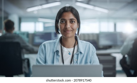 Diverse Office: Portrait of Beautiful Indian IT Programmer Working on Desktop Computer, Smiling and Looking at Camera Kindly. Female Software Engineer Creating Innovative App, Program, Video Game - Powered by Shutterstock