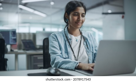 Diverse Office: Portrait Of Beautiful Smiling Indian IT Programmer Working On Desktop Computer. Female Specialist Creating Innovative Software. Professional Engineer Develop Inspirational App