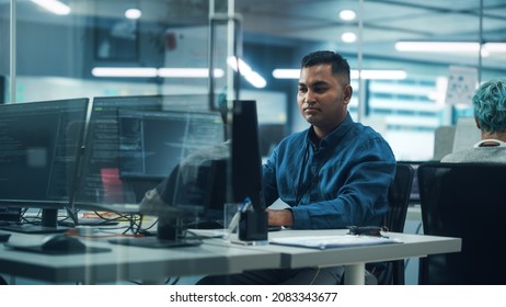 In Diverse Office: Portrait Of Handsome Indian Man Working On Desktop Computer. Professional Programmer Creates Innovative Software, Modern App Design. Stylish Multi-Ethnic Authentic Workplace