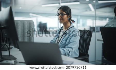 Diverse Office: Portrait of Talented Indian Girl IT Programmer Working on Desktop Computer in Friendly Multi-Ethnic Environment. Female Software Engineer Wearing Glasses Develop Inspirational App Foto d'archivio © 