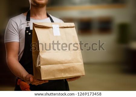 Diverse of paper containers for takeaway food. Delivery man is carrying