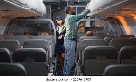 Diverse Passengers Boarding On Airplane To Fly In Economy Class, Being Seated By Flight Attendant To Travel On Vacation Trip. Talking To Stewardess In Plane, Flying With Airline Crew.