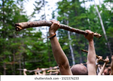 Diverse people enjoy spiritual gathering A closeup view of a bald man holding a branch above his head during an exercise blending multicultural exercises such as tai chi and yoga for body and mind. - Powered by Shutterstock