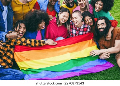 Diverse people having fun holding LGBT rainbow flag outdoor - Focus on bald girl face - Powered by Shutterstock