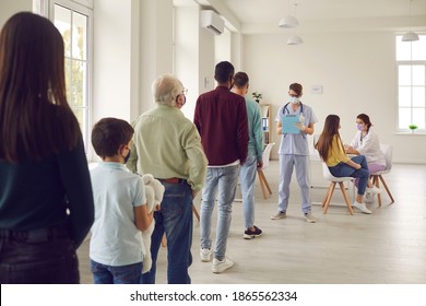 Diverse people lining up waiting for their turn to get shots at the hospital vaccination center. Young men and women, senior citizens and kids standing in queue for antiviral Covid-19 or flu vaccine - Shutterstock ID 1865562334