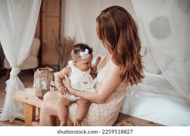 Diverse people portrait of mother with swarthy infant spending time in snugly apartment. Multi ethnic family having fun togetherness enjoying motherhood positive emotion motherly care at home - Shutterstock ID 2259518827
