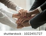 Diverse people putting stacked hands together promising help and support starting common business, black and white multiracial group unite at motivating training, team building concept, close up view