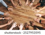 Diverse people in workout, exercise class, hands in to the middle. Teamwork with diverse hands coming together. The hands forming a frame on a wooden floor with copy space. People in workout class.