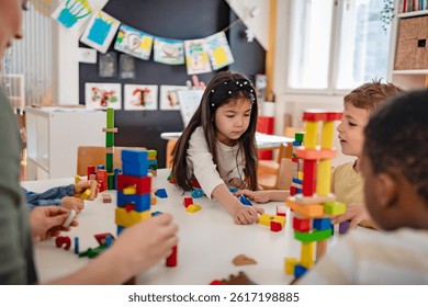 Diverse preschool children play with colorful building blocks at a classroom table, guided by a smiling teacher in a creative, inclusive early learning environment.