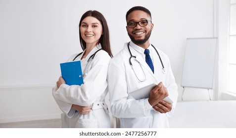 Diverse Professional Doctors In White Coats Posing To Camera At Conference Room - Powered by Shutterstock