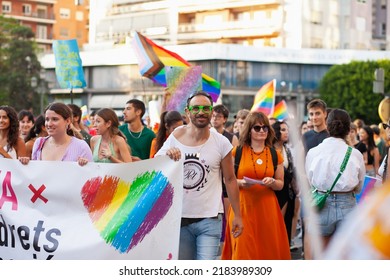 Diverse Real People Walking At Pride Parade With Rainbow Flag As Symbol Of Pride Month. Queer Community March In The Street With Crowds. LGBTQIA March, Inclusivity: VALENCIA, SPAIN - JUNE 25 2022