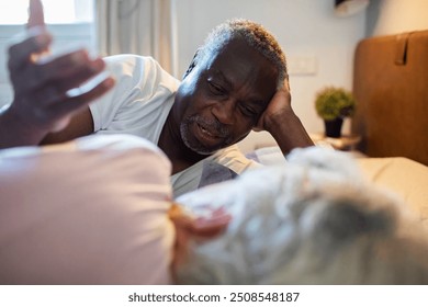 Diverse senior couple talking in bed at home - Powered by Shutterstock