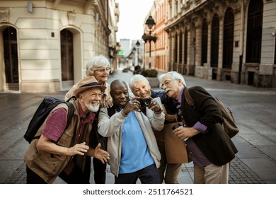 Diverse senior tourist taking group selfie downtown - Powered by Shutterstock