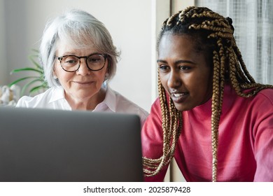 Diverse Senior And Young Woman Having Video Call On Laptop Computer At Home Office - Focus On African Girl