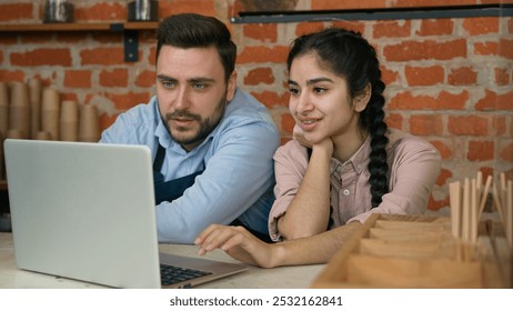 Diverse smiling waiter manager discussing working schedule on laptop cafe employees man woman looking computer screen developing new work strategy talking about business plan restaurant staff meeting - Powered by Shutterstock