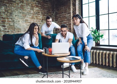 Diverse software developers reading text of program code brainstorming at collaborating meeting, male and female colleagues watching education webinar connecting to coworking wifi internet