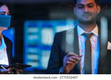 Diverse software engineers collaborating on generative AI algorithms, writing code on a glass board in a high-tech office at night. Modern tech innovation concept. - Powered by Shutterstock - Get 15% off with code: PIKWIZARD15