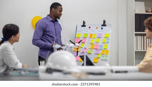 A diverse startup team develop, collaborates on a powerful, lightweight, portable wind turbine prototype, aligning with potential user demand and renewable energy needs to secure investor funding.