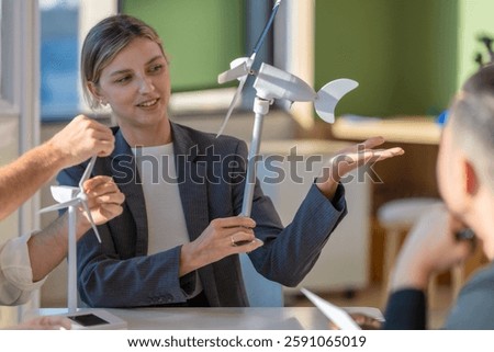 A diverse startup team develop, collaborates on a powerful, lightweight, portable wind turbine prototype, aligning with potential user demand and renewable energy needs to secure investor funding.