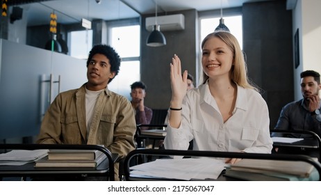 Diverse students classmates attentively listening to interesting lecture enthusiasm in classroom young caucasian girl raising hand knows answer answers question higher education concept in college - Shutterstock ID 2175067047