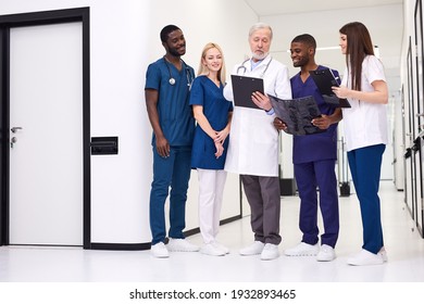 Diverse Students At Medical Practice In Hospital, Young Men And Women Adopt Experience Of Senior Male Doctor, Studying - Powered by Shutterstock