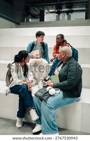 Diverse students studying and conversing, learning together on campus steps, collaborating research for education goals