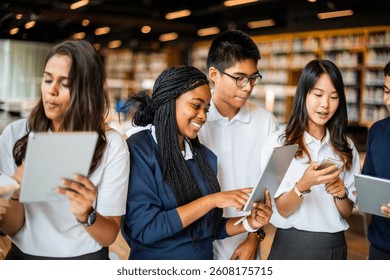 Diverse students using tablets in a library. Students engaged with technology, learning, and collaborating. Education and technology in a library. Diverse students in library, education concept. - Powered by Shutterstock - Get 15% off with code: PIKWIZARD15